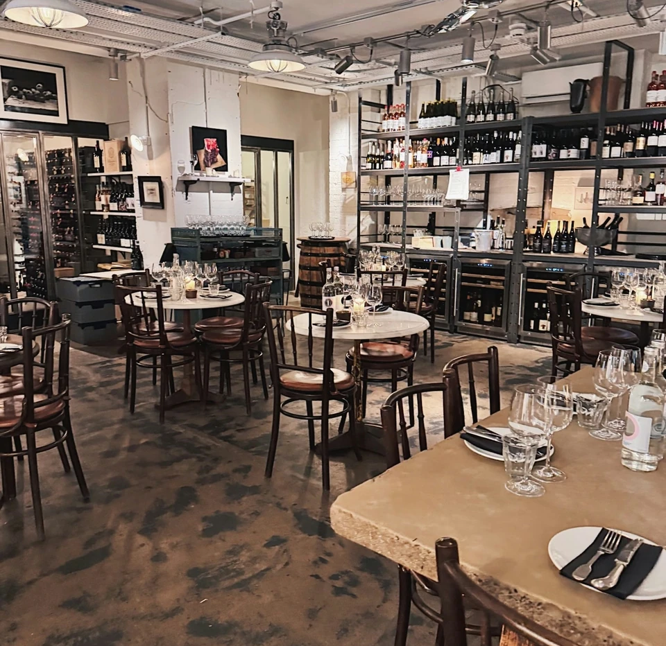 Farm Shop wine bar interior with stocked shelves, set tables and wine glasses