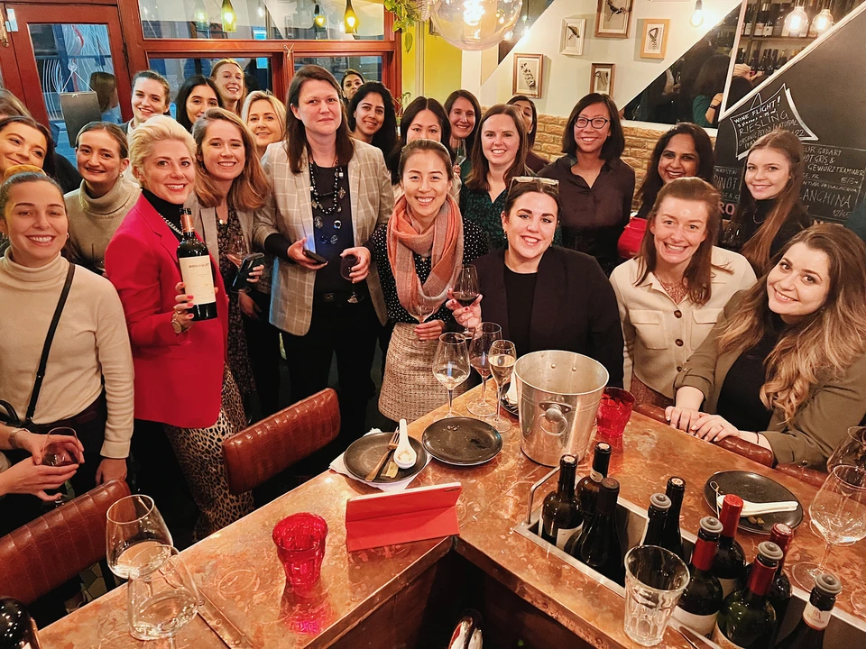 Guests holding wine glasses and a bottle at a Furmint tasting