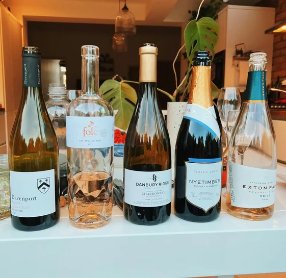 A selection of English wine bottles and filled glasses arranged on a table