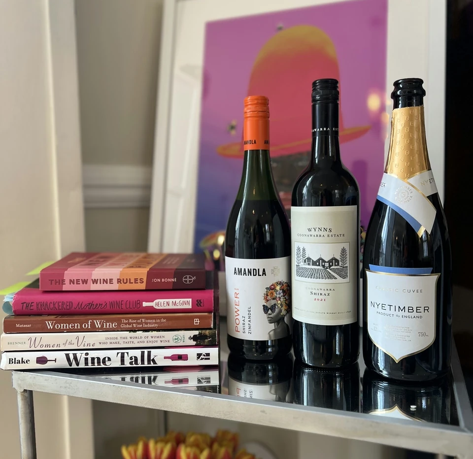 A Nyetimber bottle displayed with two other wine bottles and books about women in wine