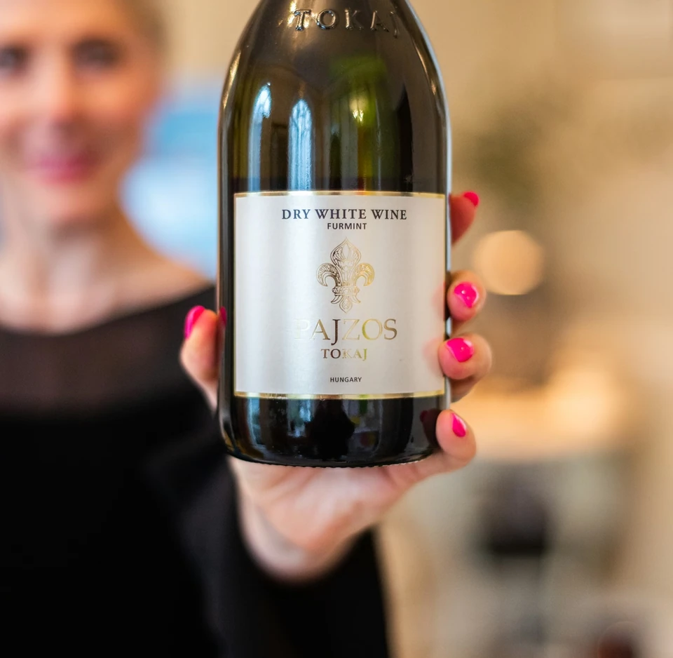 Bottle of Pajzos Tokaj dry white Furmint wine held in front of a blurred person