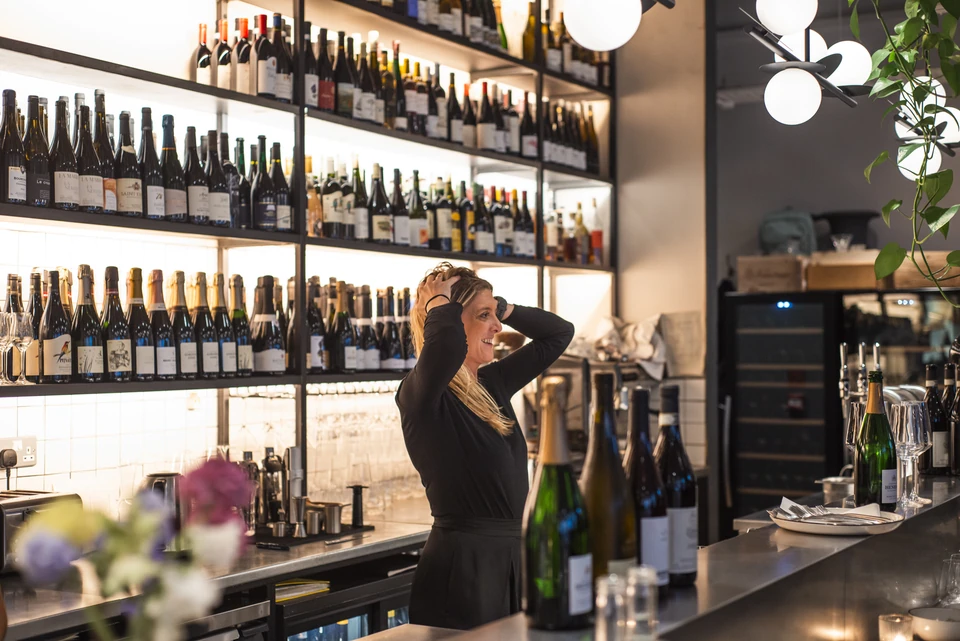 Bartender standing behind the wine bar at Stem + Stem