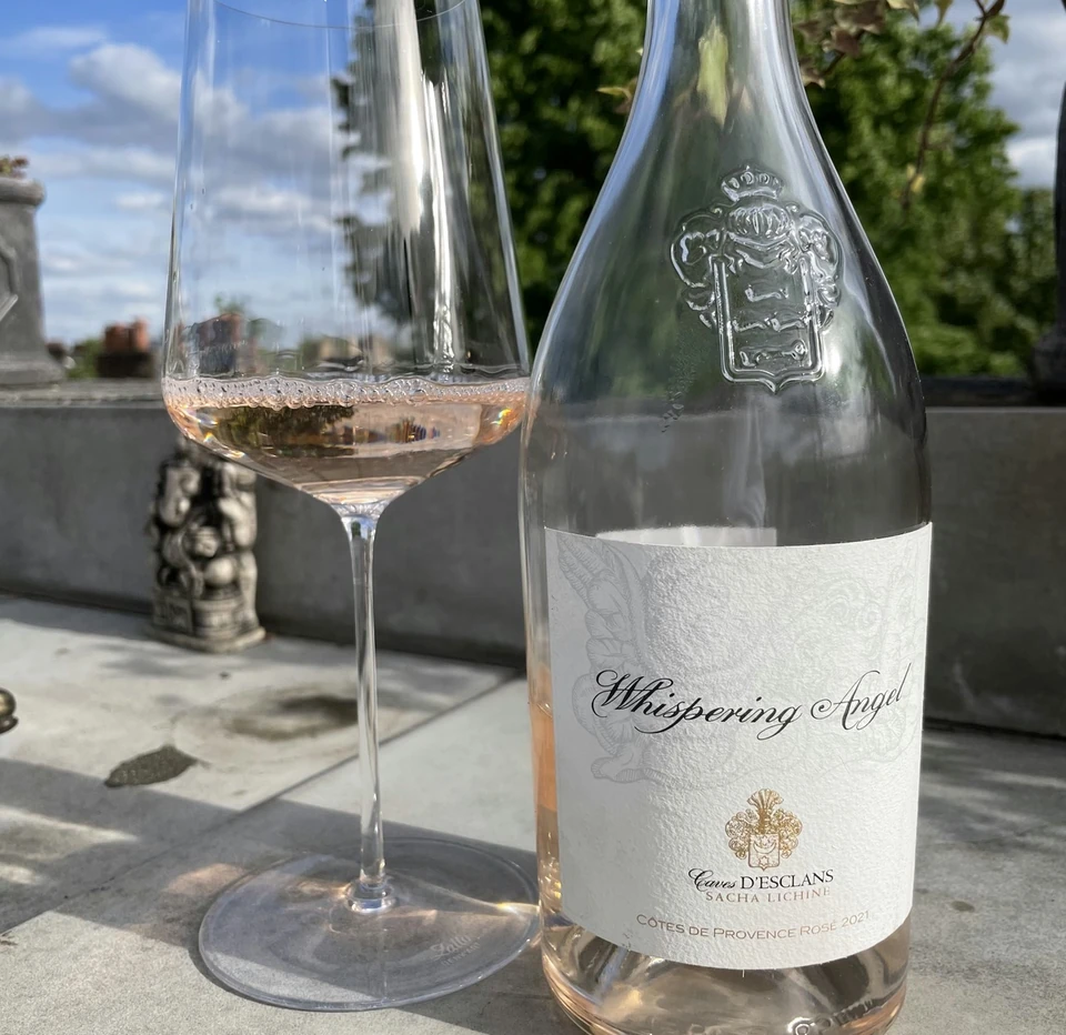 Whispering Angel rosé beside a glass of wine in bright sunshine