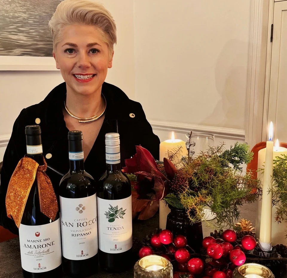 Three Tedeschi Valpolicella wine bottles on a festive candlelit table
