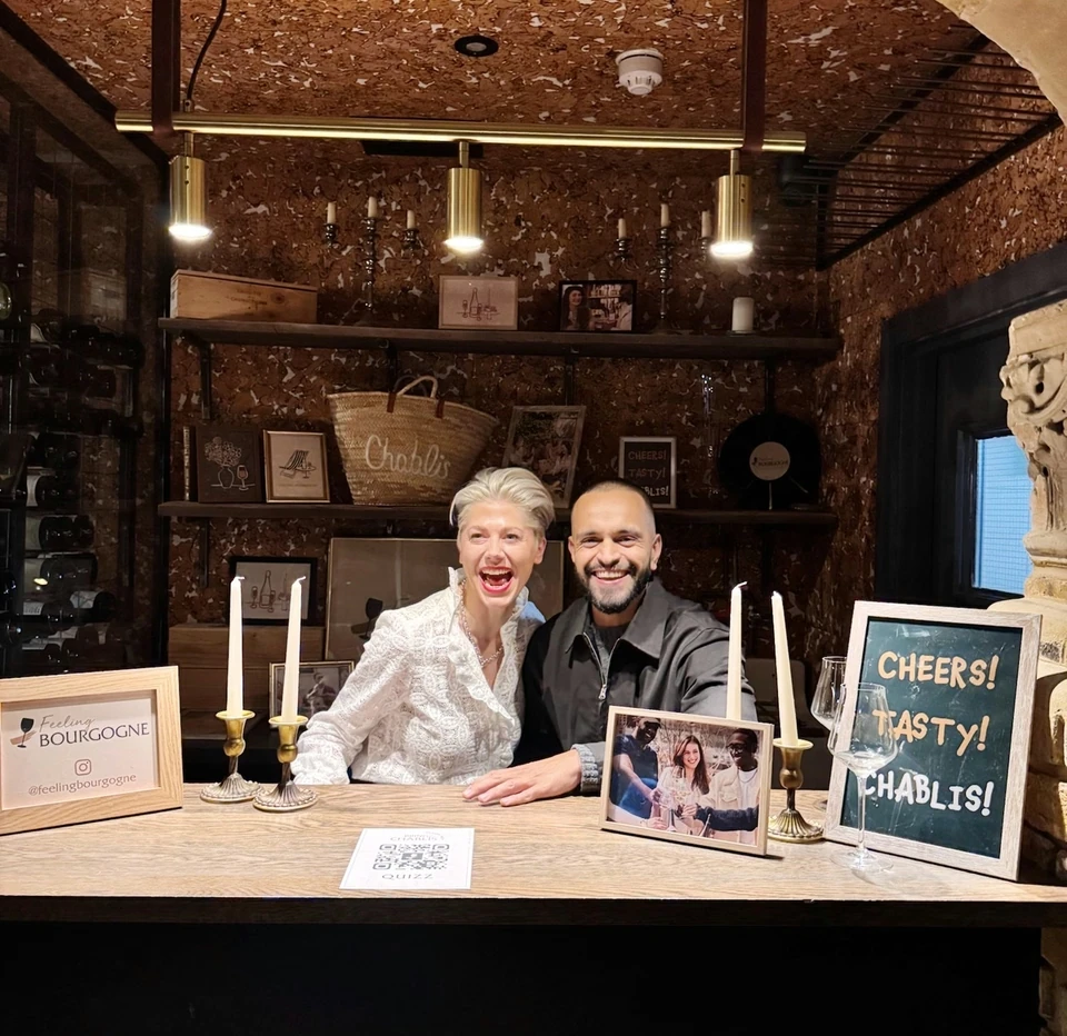 Two people behind a Chablis tasting table in a cosy wine bar