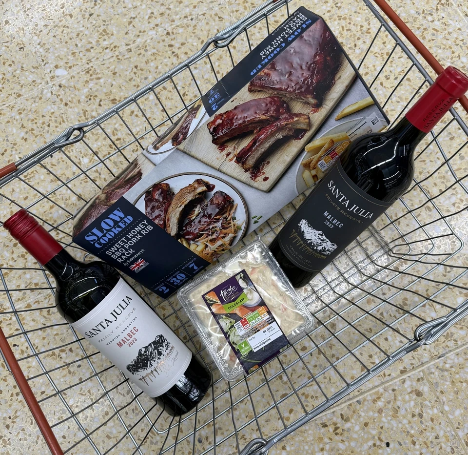 Santa Julia Malbec bottles with barbecue ribs, chips and coleslaw in a shopping basket