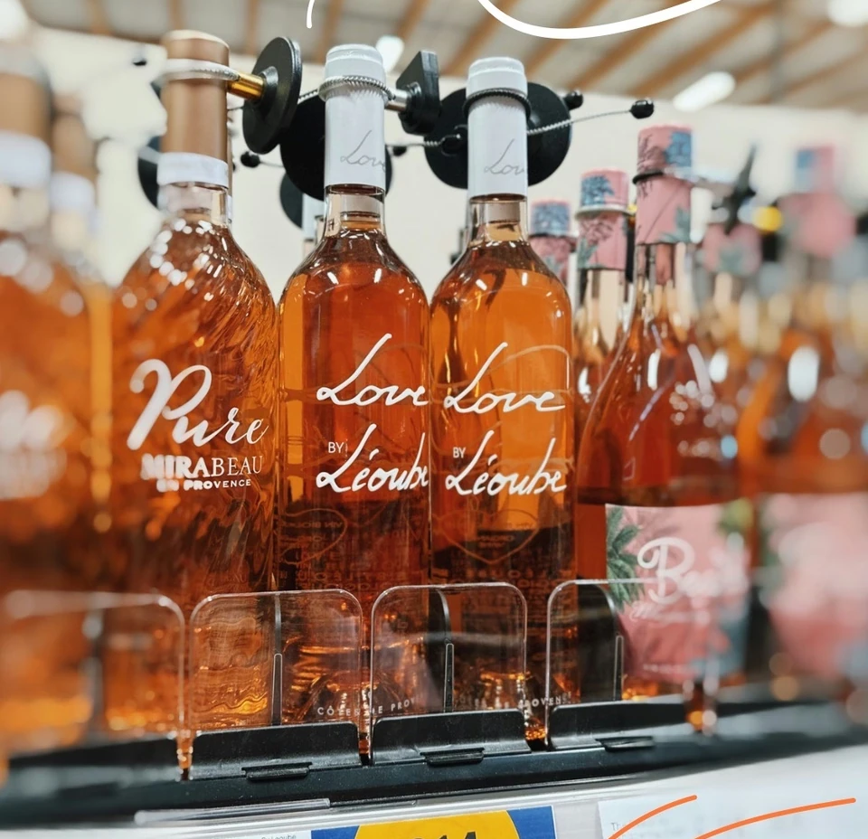 Rosé wine bottles displayed on a Tesco supermarket shelf with price labels