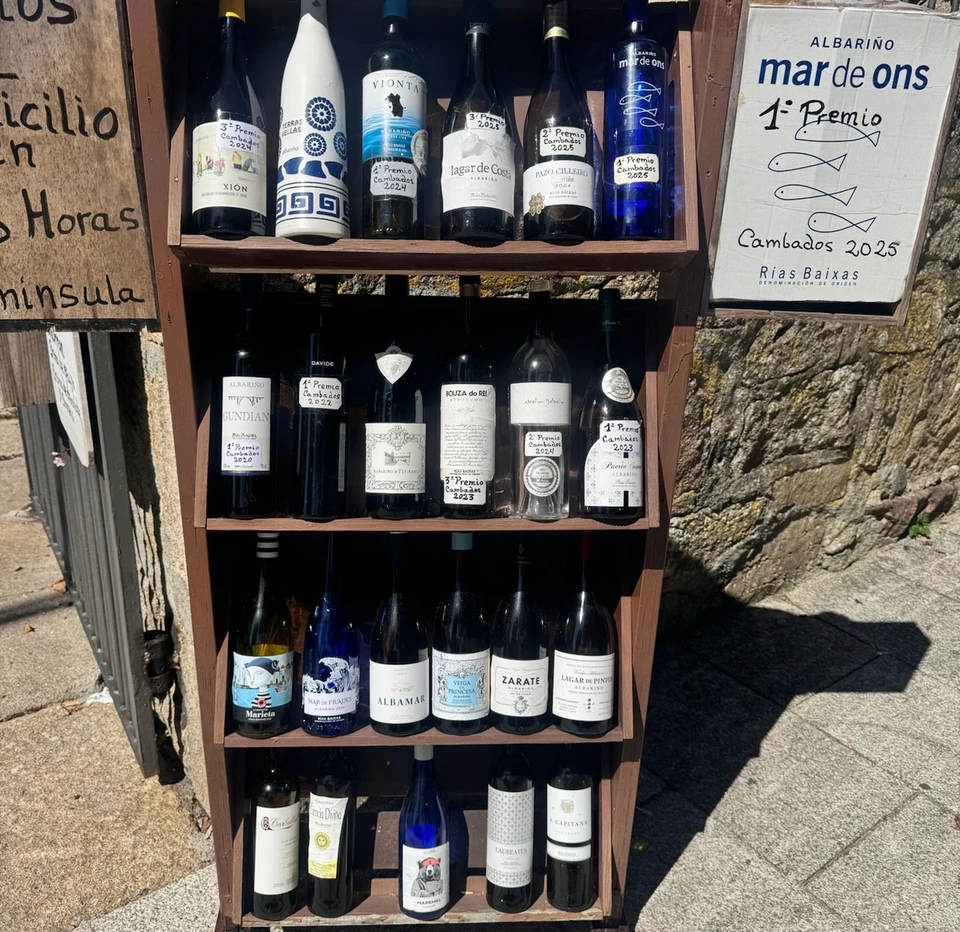 Display of Albariño wine bottles beside a Rías Baixas sign outdoors