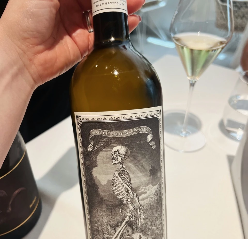 Bottle of 2022 Kalamity Rioja beside a glass of pale wine