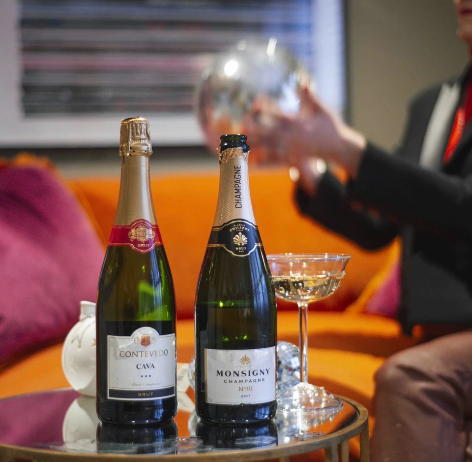 Two bottles of sparkling wine and glasses on a drinks trolley at an Aldi tasting