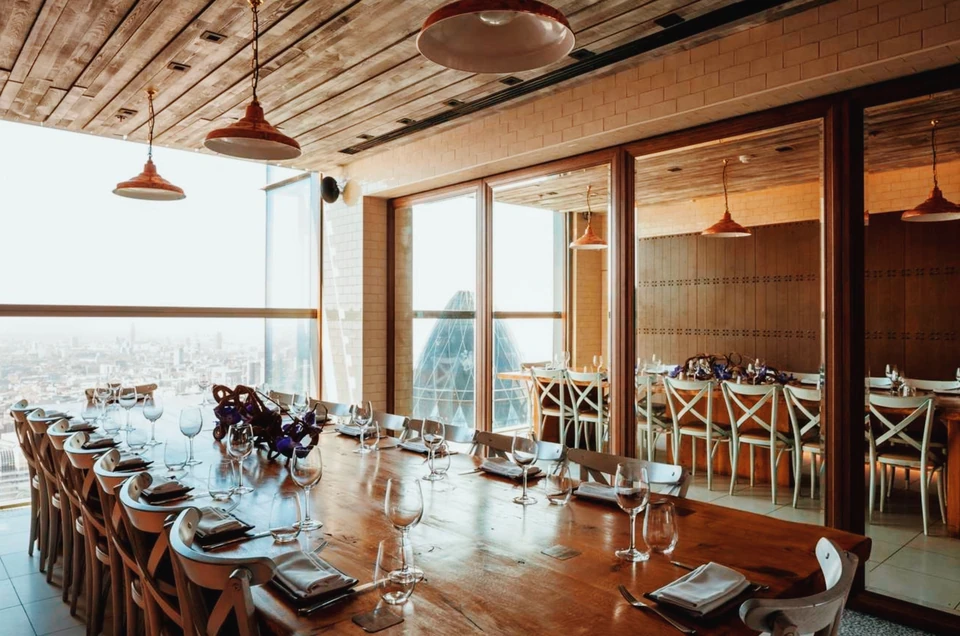 Duck & Waffle dining room with a London panorama, wooden tables, marble, tiled walls and copper pendant lights