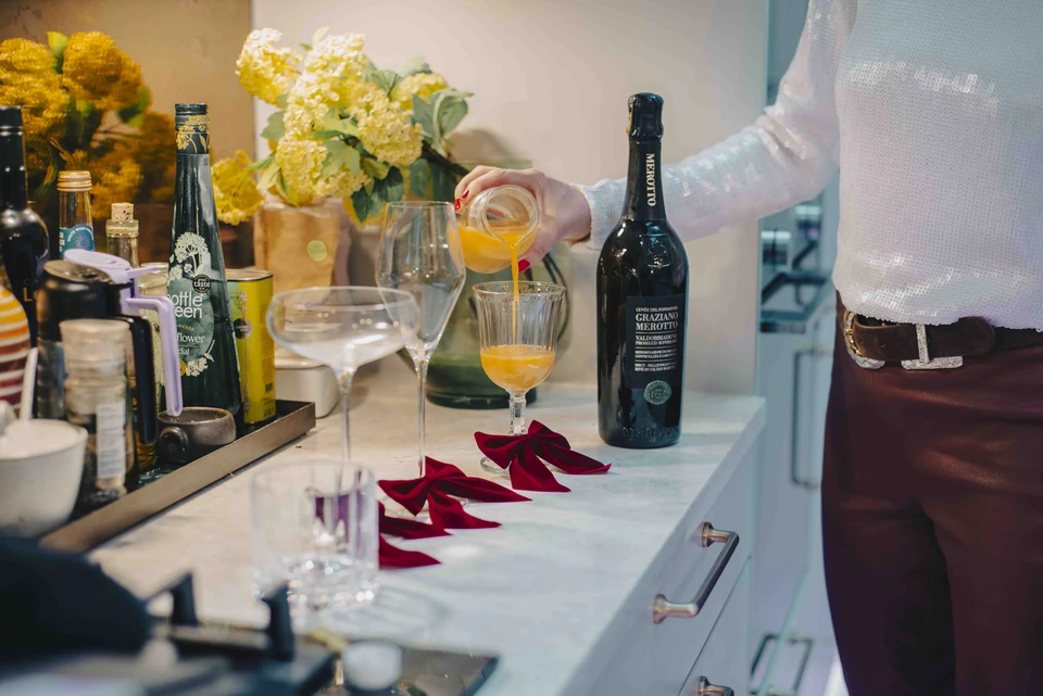 Pouring an orange cocktail beside a bottle of Graziano Merotto Prosecco