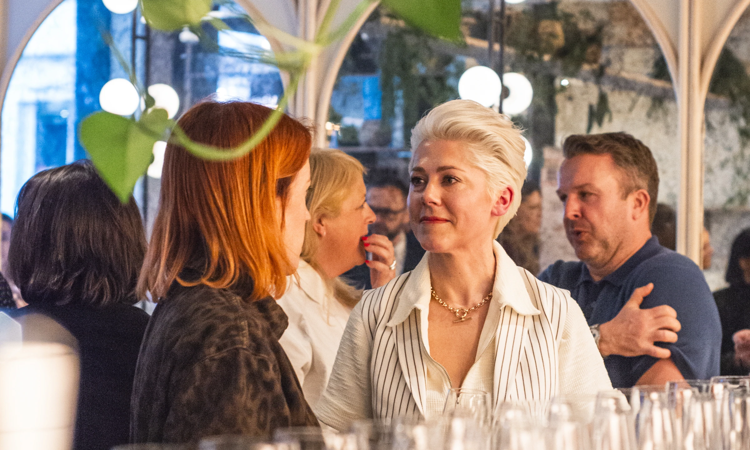 Guests talking along a bar lined with tasting glasses