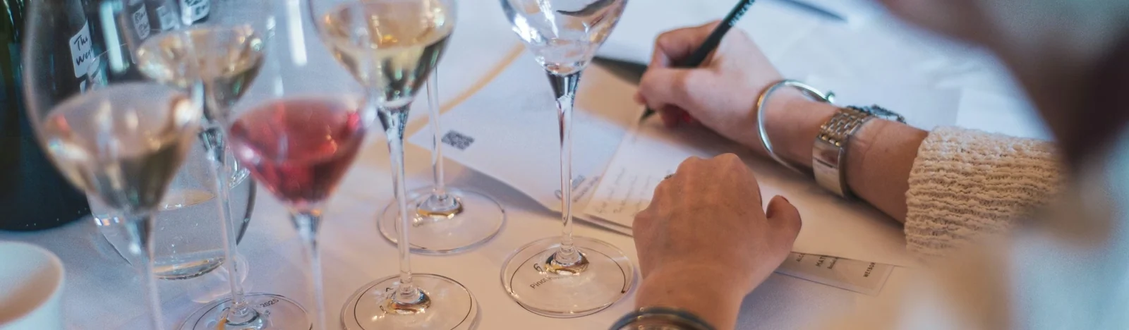 Wine tasting table with glasses, bottles and tasting notes