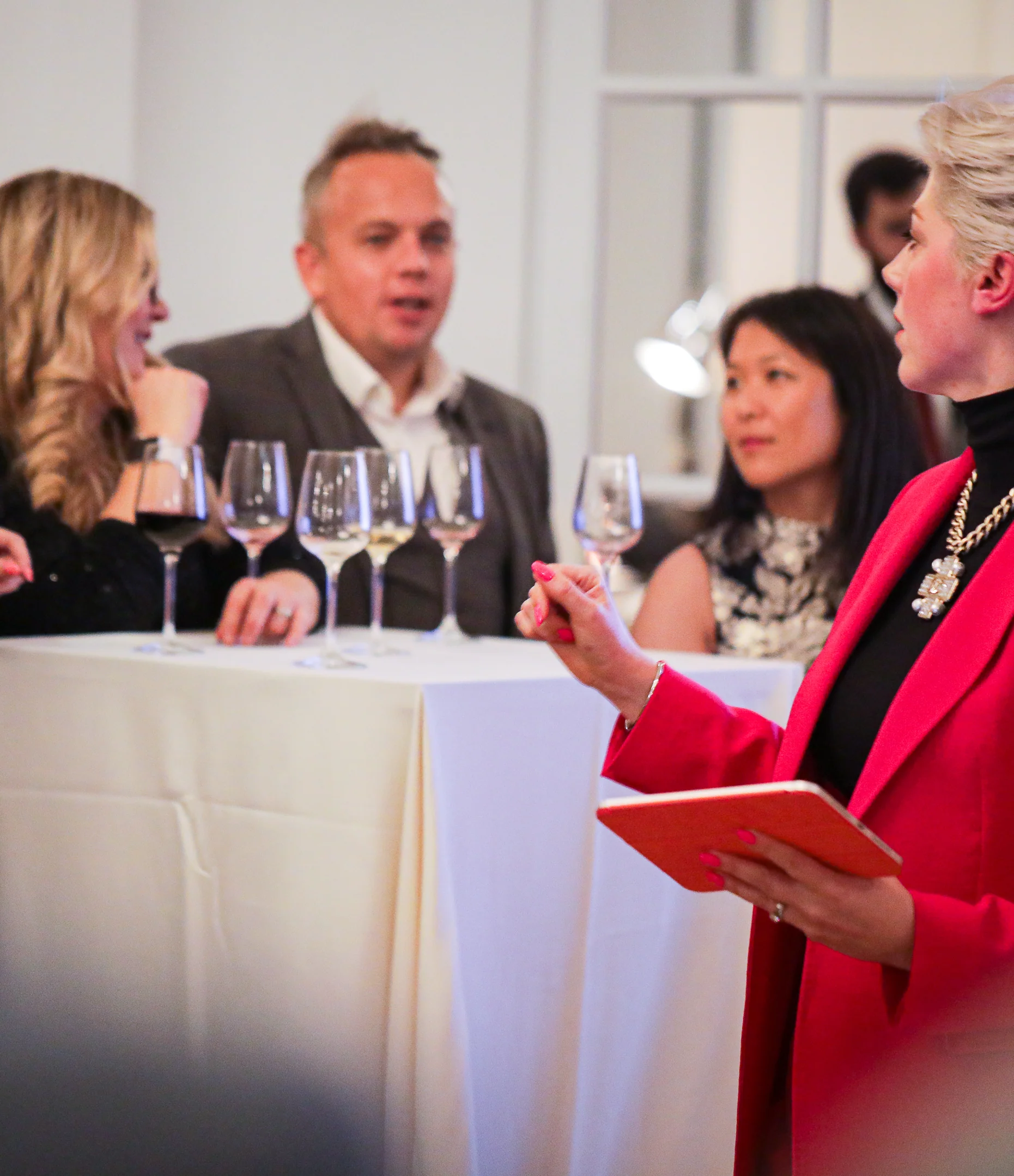 Elizabeth Hawthornthwaite presenting a flight of wines to a group, notes in hand